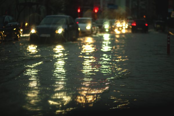 Flooded road with cars in city.
