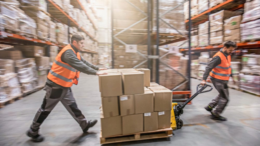 Return to Work program, two men moving boxes in a warehouse