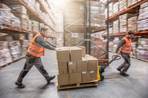 Return to Work program, two men moving boxes in a warehouse