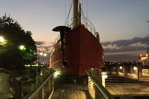 Lightship Portsmouth at evening, dramatic shot from dock facing red bow.