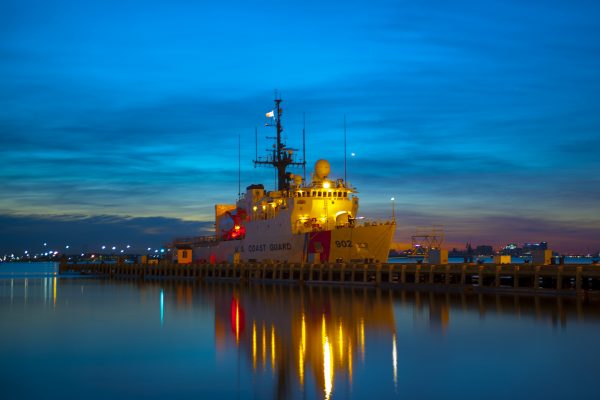 Coast Guard Cutter Tampa, homeport in Portsmouth, Va., shown docked against royal blue sky during sunrise.