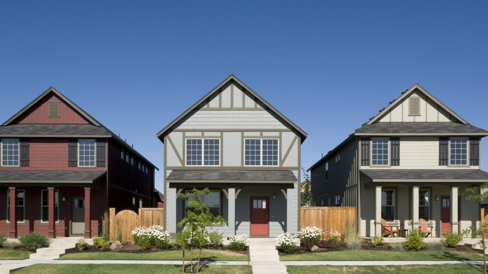 Homeowners insurance deductible, row of three similar houses on a neighborhood street.