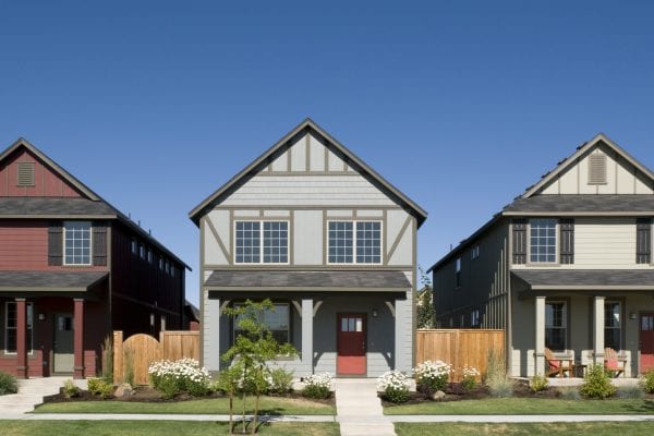 Homeowners insurance deductible, row of three similar houses on a neighborhood street.