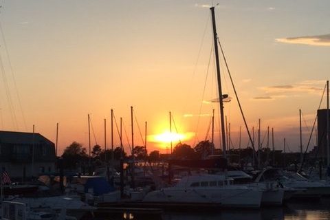 Sunset over a harbor with small craft and sailboats in Portsmouth, VA.