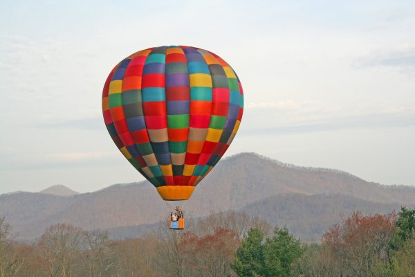 Asheville, NC Insurance Agency, colorful hot air balloon over Appalachian mountains in winter.
