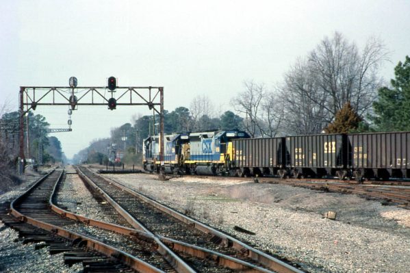 Newport News, VA CSX Railroad two blue CSX railroad engines pulling line of empty coal cars on railway.