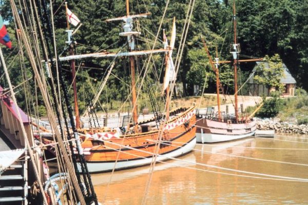 Newport News, VA Jamestown settlement area, three large reproduction multi-masted wooden sailing ships lashed to a dock.