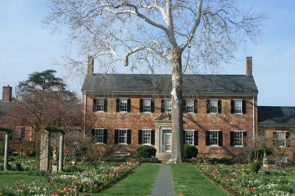 Fredericksburg, VA Chatham Manor, sprawling two story brick home with slate roof and gardens with tulips in front.