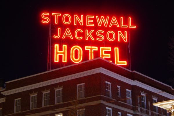 Staunton, VA Stonewall Jackson Hotel, iconic neon orange sign glowing atop tall brick hotel.