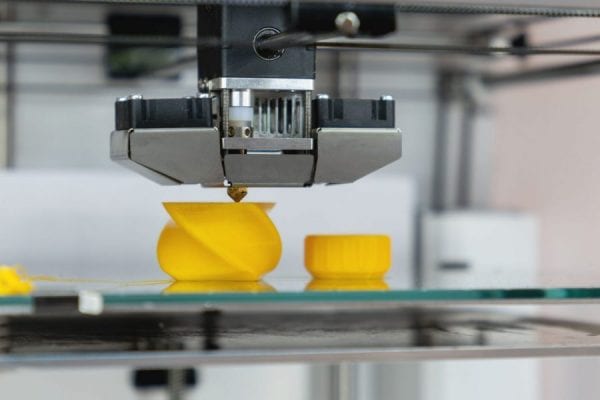 3D printer printing a yellow twisty model symbolizing claim analytics in manufacturers insurance