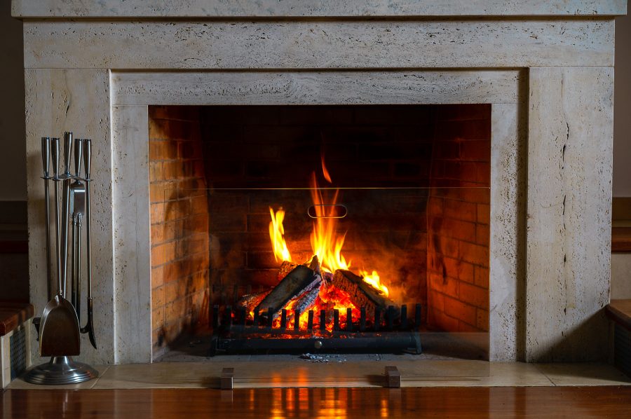A fireplace with fire and clean and safe surrounding area.