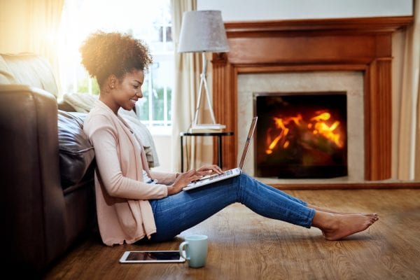 A homeowners insurance client in front of her fireplace.