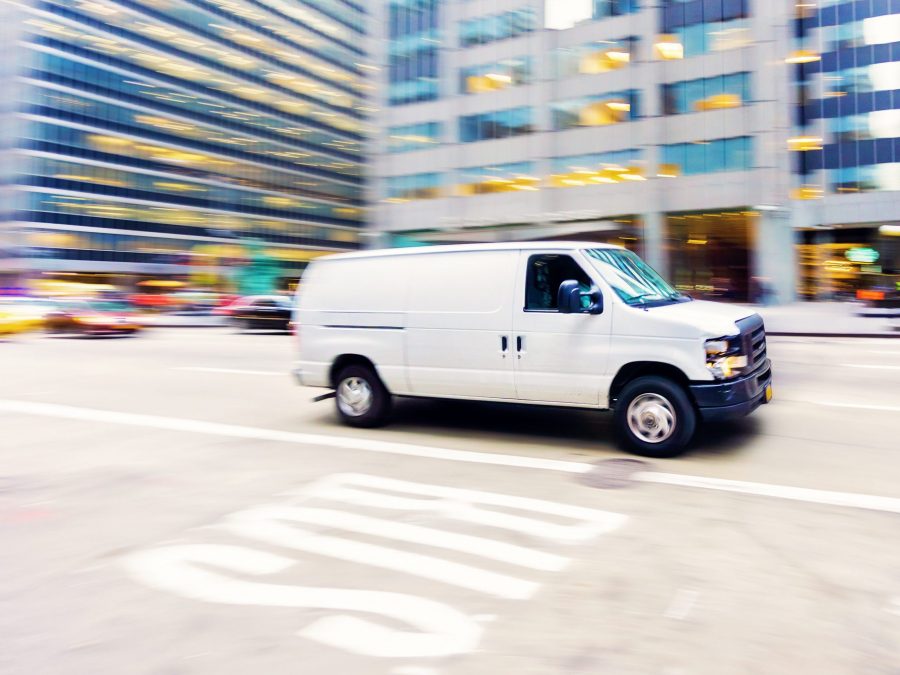 Commercial white van in city.