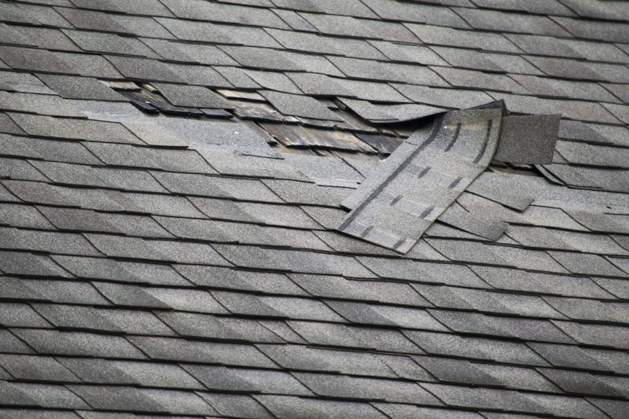 Area of damaged shingles on a roof, surrounded by good shingles.