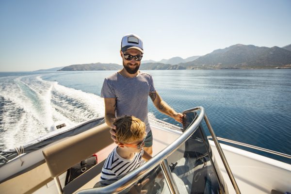 Father and son on boat on lake in mountains.