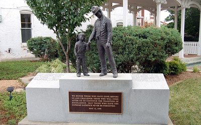 Bronze statue of policeman holding hand of small girl.